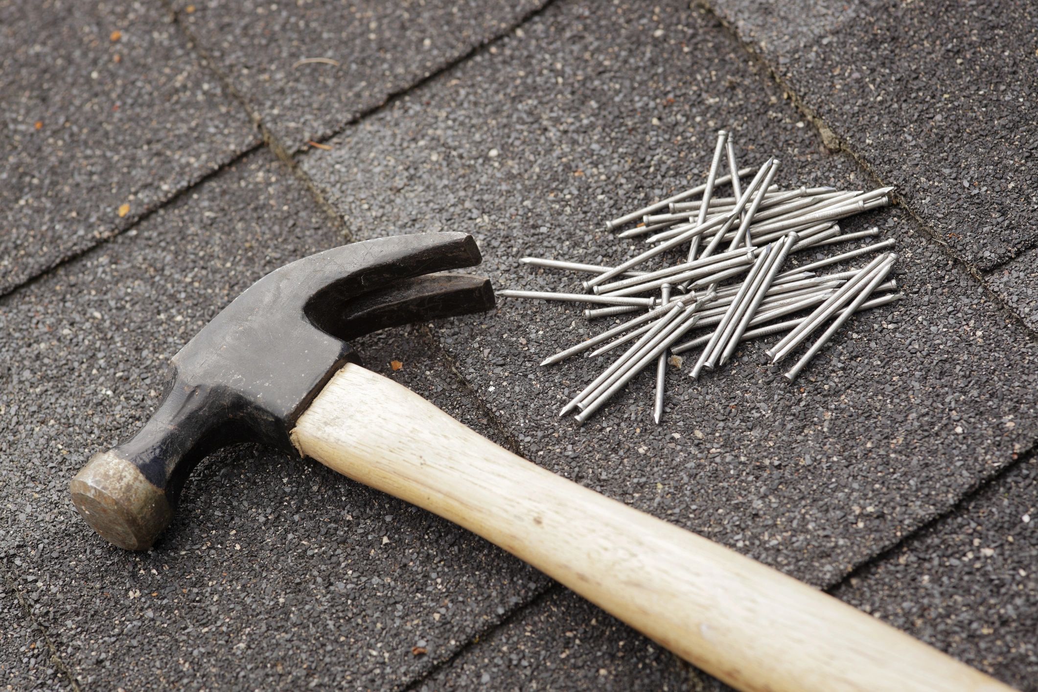Roofing professional performing repair work on a shingle roof