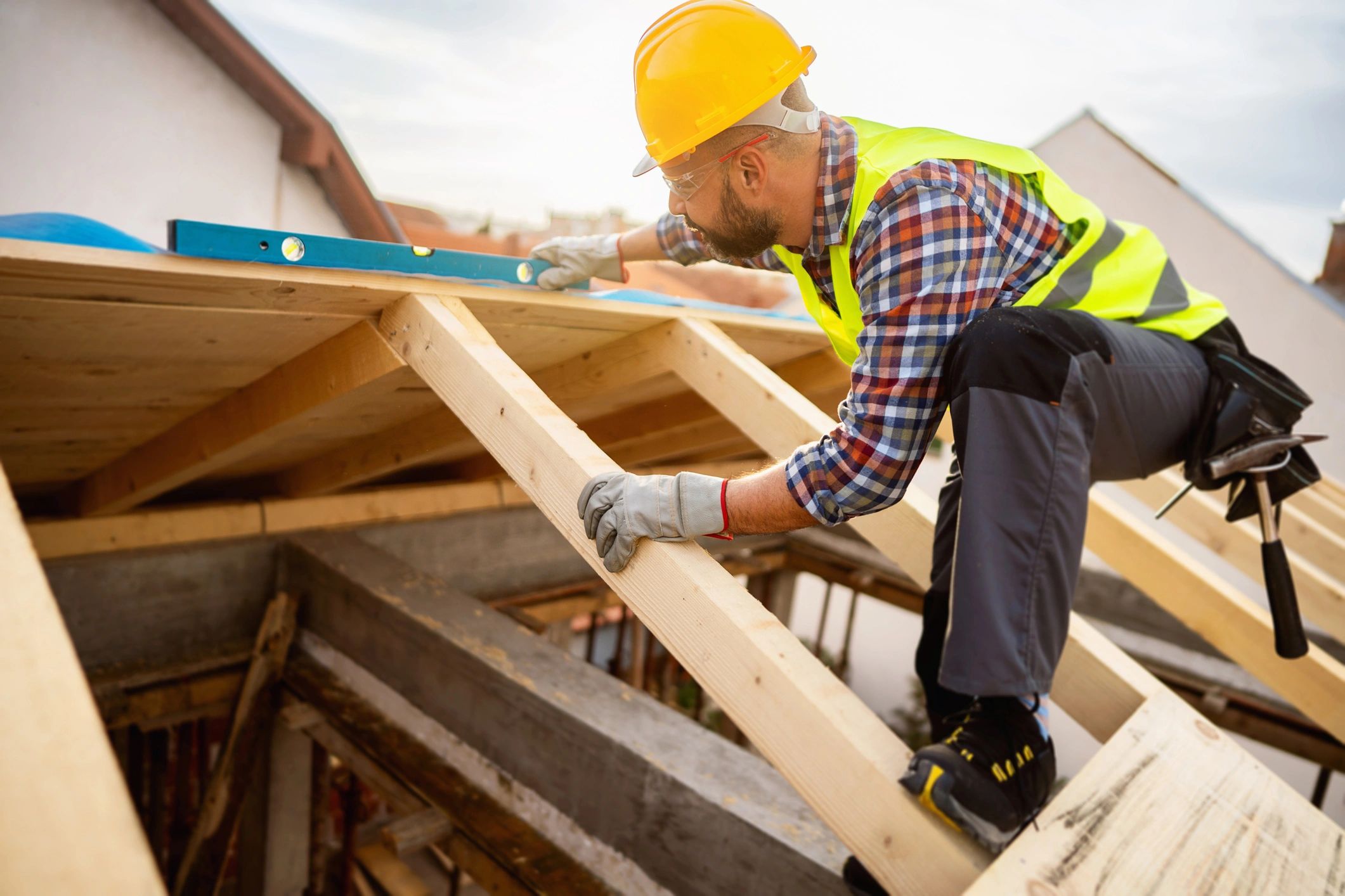 Roofer performing a careful roof inspection on a construction site