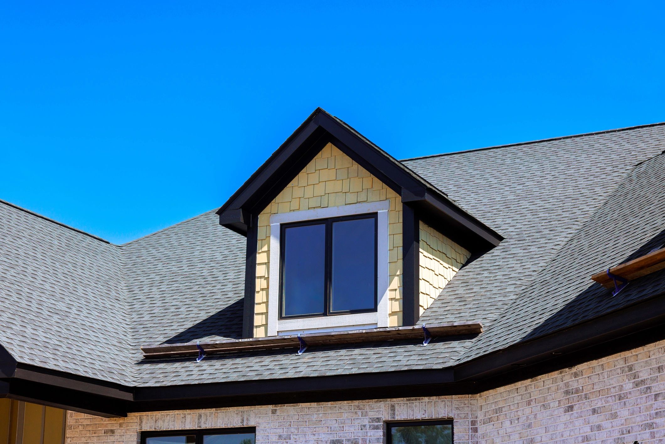 Modern home exterior with prominent roofline under a clear sky